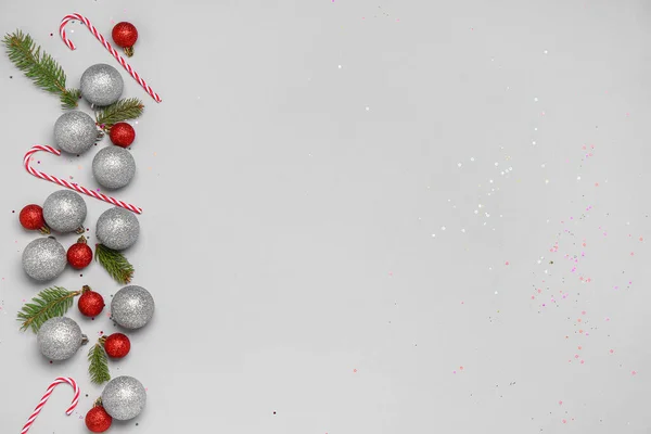 Weihnachtskugeln Mit Tannenzweigen Und Zuckerstangen Auf Grauem Hintergrund — Stockfoto