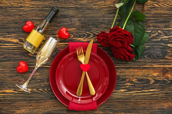 暗い木製の背景にシャンパンとバラのボトルとバレンタインデーのテーブル設定 — ストック写真