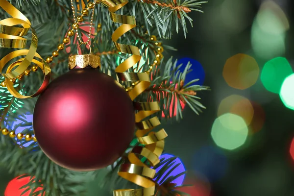 モミの木の上にサーペンタインとビーズの赤いクリスマスボール クローズアップ — ストック写真