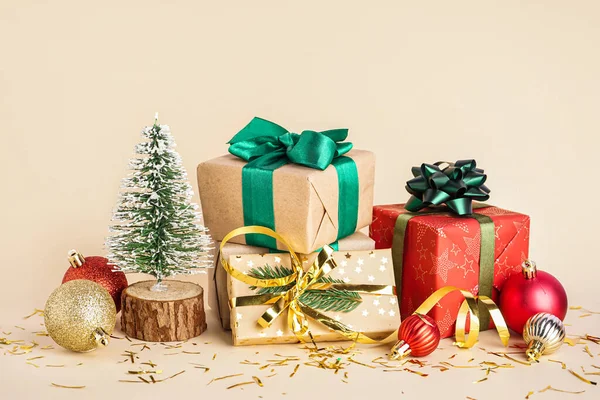 ベージュの背景にクリスマスボールとモミの木の贈り物 — ストック写真