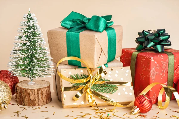 Geschenke Mit Weihnachtskugeln Und Tanne Auf Beigem Hintergrund — Stockfoto