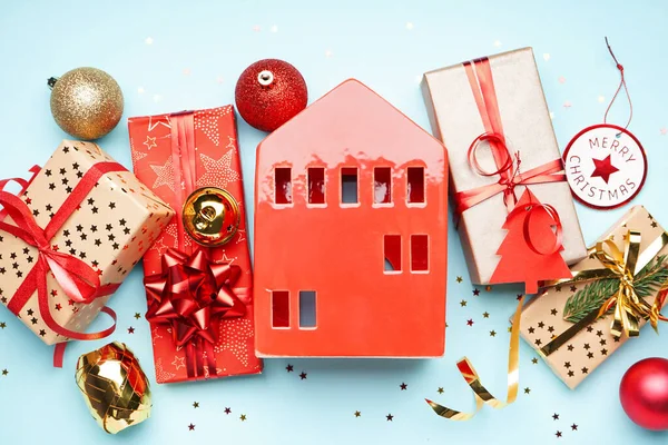 青を背景にクリスマスボールと贈り物付きの家型キャンドルホルダー — ストック写真