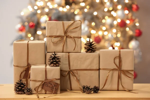 Κουτιά Δώρων Στο Τραπέζι Κατά Θολή Χριστουγεννιάτικο Δέντρο — Φωτογραφία Αρχείου