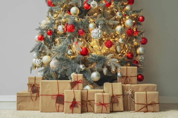 Gri Duvarın Yakınındaki Parıldayan Noel Ağacının Altındaki Hediyeler — Stok fotoğraf