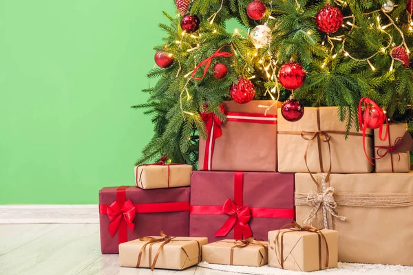 Ajándékok Alatt Izzó Karácsonyfa Közelében Zöld Fal — Stock Fotó
