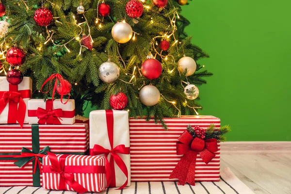 Ajándékok Alatt Izzó Karácsonyfa Közelében Zöld Fal — Stock Fotó