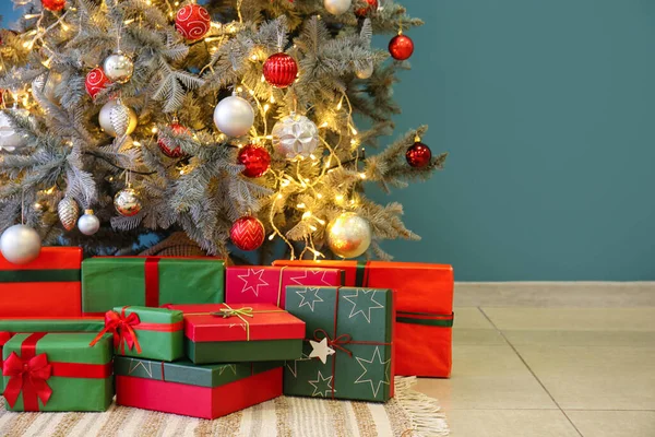 Ajándékok Alatt Izzó Karácsonyfa Közelében Kék Fal — Stock Fotó