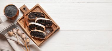 Beyaz ahşap zemin üzerinde lezzetli haşhaşlı turta parçaları ve metin için yer var.