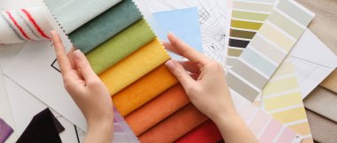 Masada kumaş örnekleri olan bir kadın var.