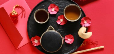 Çin fal kurabiyesi ve kırmızı arka planda çay ile kompozisyon, üst görünüm