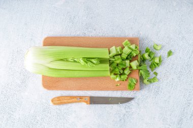 Tahta tahta, taze kereviz ve arka planda bıçak.