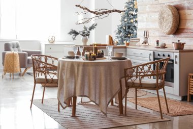 Noel sofrasında yanan mumlar ve mutfakta çelenkler.