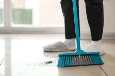 Kadın süpürgeyle yerleri süpürüyor