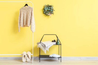 Noel ökseotu çelengi, askı ve raf ünitesi olan bir oda.