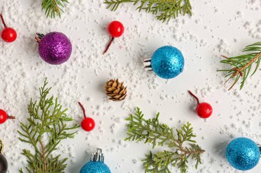 Topları olan Noel dalları, beyaz arka planda rowan ve kar