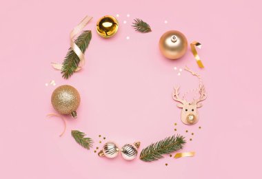 Pembe arka planda güzel Noel süslemeleri ve köknar dallarından yapılmış çerçeve