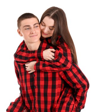 Dişli pijamalı genç çift beyaz arka planda sarılıyorlar.