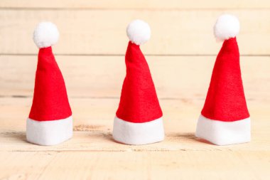 Hafif ahşap arka planda Noel Baba şapkaları