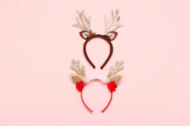 Pembe arka planda iki Noel geyiği boynuzu