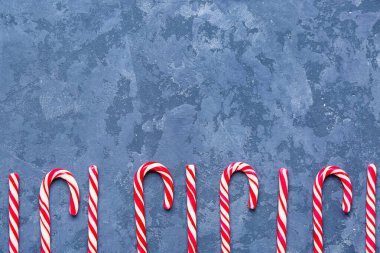 Renkli arkaplanda lezzetli baston şekerlerle kompozisyon