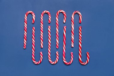 Renkli arkaplanda lezzetli baston şekerlerle kompozisyon