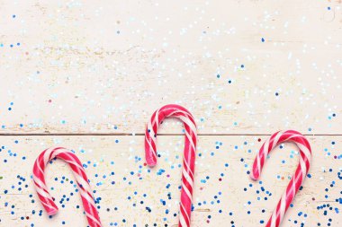 Tatlı baston şekerler ve hafif ahşap arka planda pullar, yakın plan.