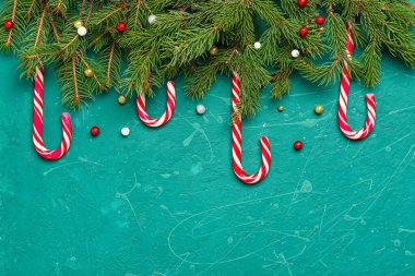 Lezzetli şeker kamışları, köknar dalları ve arkaplanda Noel dekoru olan kompozisyon