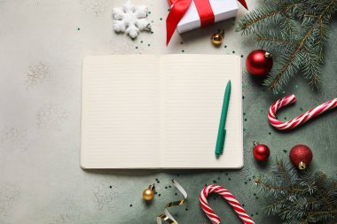 Boş defter, kalem, köknar dalları ve grunge arkaplanda Noel süslemeleri içeren kompozisyon