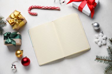 Boş defter, Noel hediyeleri ve arka planda süslemeleri olan kompozisyon