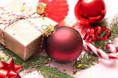 Noel hediyesi, süslemeler ve pembe arka planda köknar dalları, yakın plan.