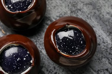 Koyu ahşap tahtada çikolatalı şekerler, yakın plan.