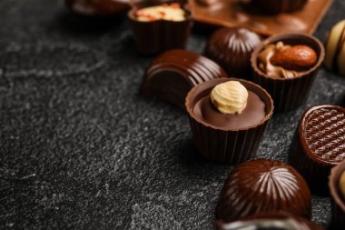 Siyah arkaplanda farklı çikolata şekerlemeleri, yakın plan