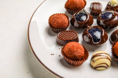 Beyaz arka planda çikolatalı şekerler, yakın plan.