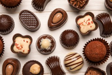 Beyaz ahşap arka planda çikolatalı şekerler