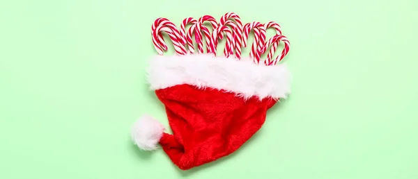 Weihnachtsmütze Mit Zuckerstangen Auf Hellgrünem Hintergrund — Stockfoto