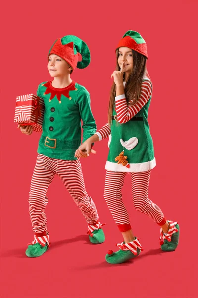 Kleine Kinder Elfenschlafanzug Mit Weihnachtsgeschenk Auf Rotem Hintergrund — Stockfoto