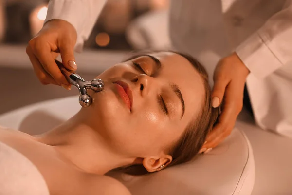 Mulher Bonita Recebendo Massagem Facial Com Rolo Salão Beleza — Fotografia de Stock
