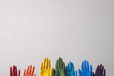 Gri arka planda boyanmış avuç içleri olan eller. LGBT kavramı