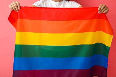 Renk arkaplanına karşı LGBT bayrağı tutan kadın, yakın plan