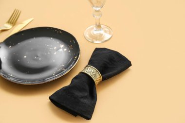 Bej arka planda siyah plakalı zarif masa ayarı, yakın plan