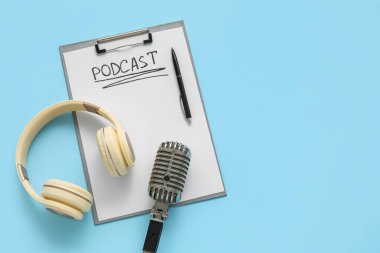 Üzerinde PODCAST, kalem, kulaklık ve mikrofon olan pano mavi arka planda