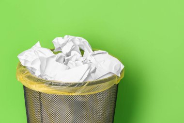 Yeşil arka planda buruşuk kağıtlı ofis kutusu, yakın plan.