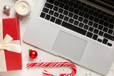 Yılbaşı topları, mum, hediye ve şeker kamışlı dizüstü bilgisayar.