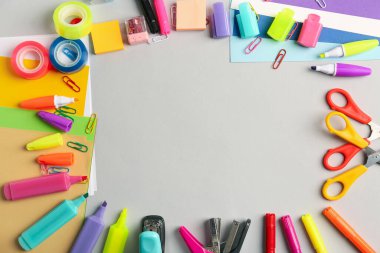 Gri arkaplandaki farklı kırtasiyeden yapılmış çerçeve