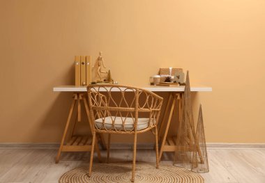 Noel dekoru, hediyesi, kahve fincanı ve bej duvarın yanındaki mankenli işyeri.