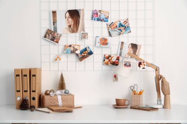 Işık duvarının yanındaki masada klasörlü ve fincanlı Noel hediyesi.