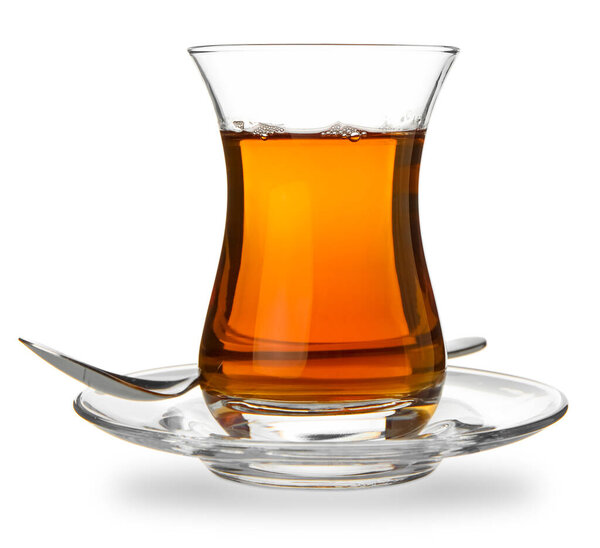 Glass of Turkish tea with spoon on white background