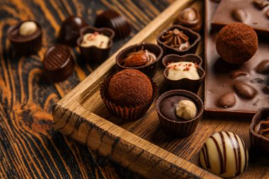 Tahta arka planda çikolatalı ve şekerli pano, yakın plan.