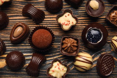 Tahta arka planda çikolatalı şekerler, yakın plan.