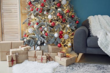 Oturma odasında hediyelerle parlayan Noel ağacı